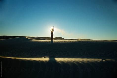 A Beautiful Silhouette Of A Naked Girl In The Sand Dunes Throwing Sand