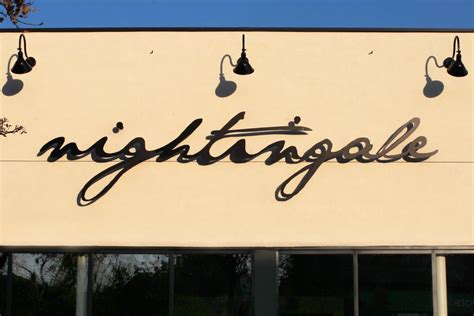 The Sign On The Building Says Nighttroople In Cursive Writing With