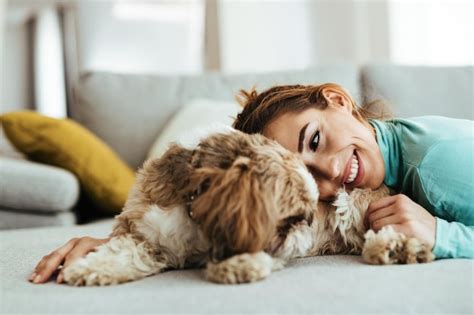 Free Photo Affectionate Woman Cuddling Her Dog While Relaxing At Home