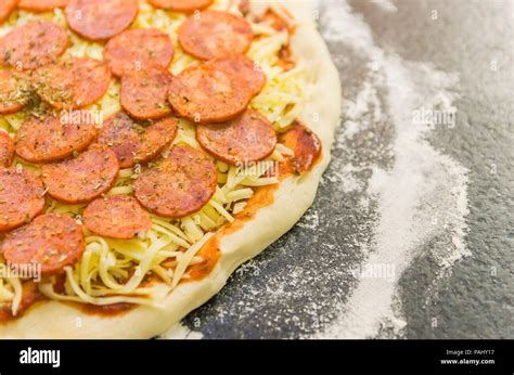 Preparing pepperoni pizza on black granite table Stock Photo - Alamy