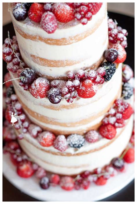 A Three Tiered Cake With Berries And Powdered Sugar On The Top Is Shown