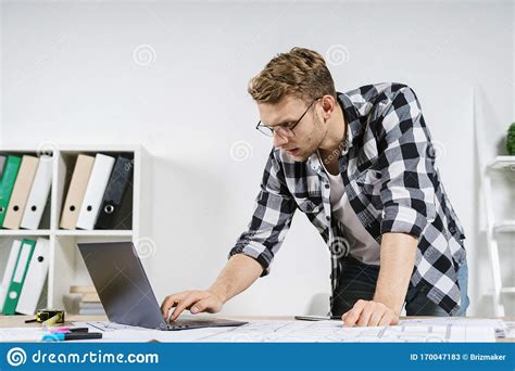 Young Adult Architect Working With Blueprints In Workspace Office Stock