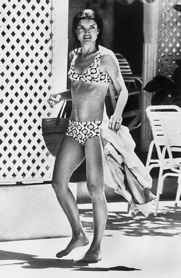 An Old Photo Of A Woman In A Bathing Suit Walking On The Sidewalk With