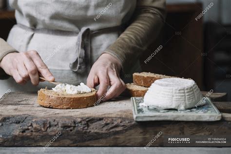 Woman Spreading Ricotta Cheese Onto Slice Of Bread Mid Section Cream