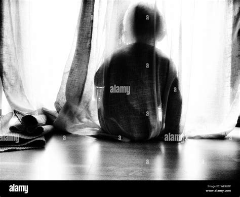 Rear View Of Child Hiding Behind Curtain Stock Photo Alamy