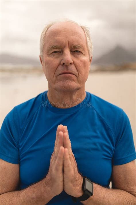 Senior Man Meditating In Prayer Position On The Beach Stock Image