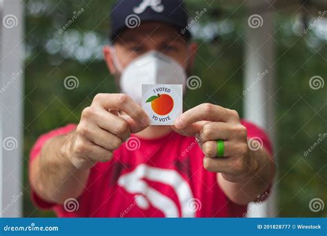 A Georgia Voter Wearing A Mask Holds Up His I Voted Sticker After Voting In The 2020 Us