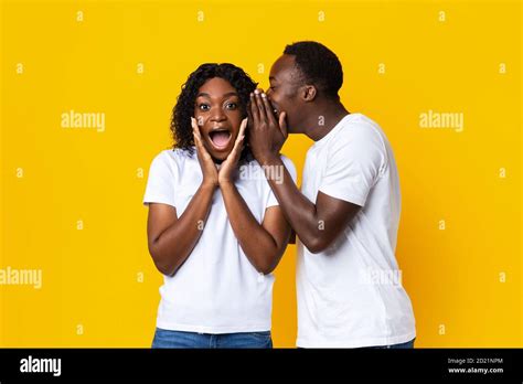 Black Man Sharing Secret With His Amazed Girlfriend Stock Photo Alamy