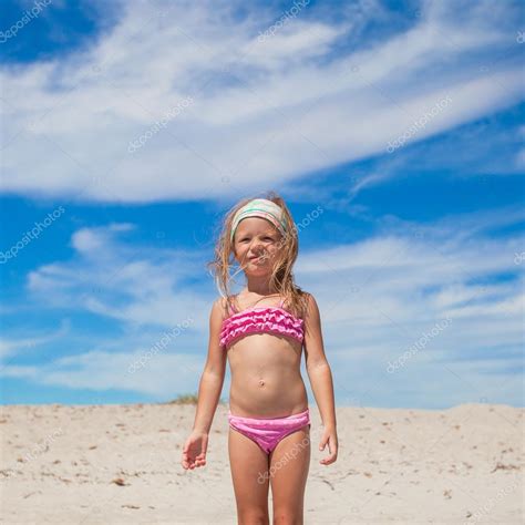 очаровательны маленькая девочка в красивых купальниках повеселиться на тропическом пляже