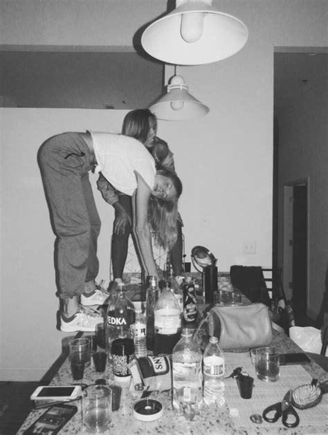 Black And White Photograph Of Two People Bending Over A Table Full Of