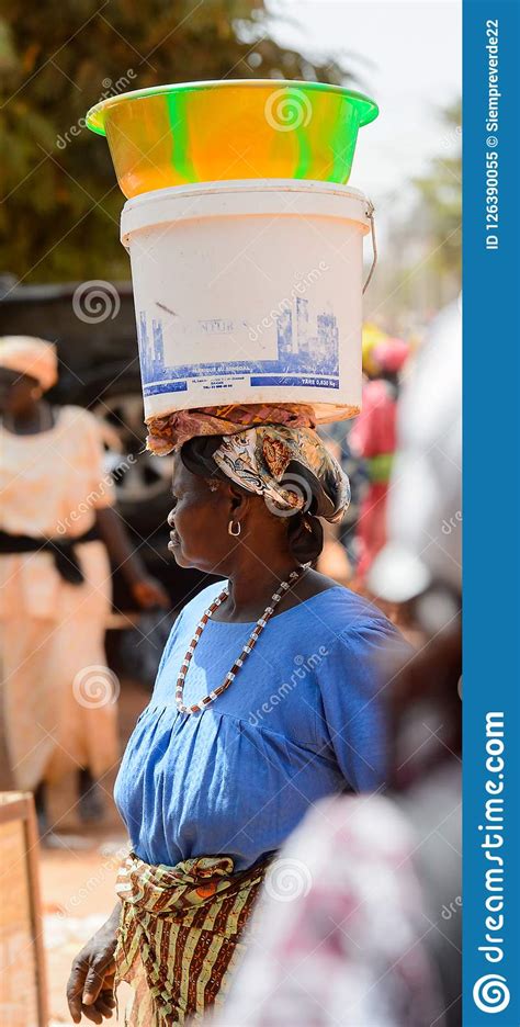 unidentified local woman carries a bucket on her head in the ce editorial image image of