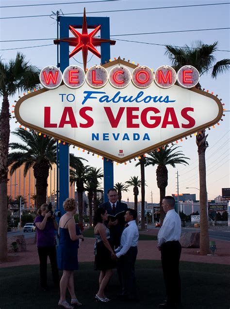 Couple Getting Married Under The Welcome To Fabulous Las Vegas Sign