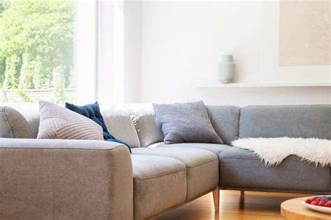 Pillows On Grey Corner Couch In Scandinavian White Living Room Interior