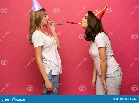 Close Up Portrait Of Blonde And Brunette Young Women With Birthday Hats Having Fun Isolated On