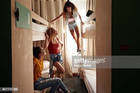Young Women Arriving To Room With Bunk Beds At Youth Hostel Photo