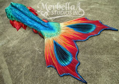 A Colorful Fish Laying On The Sand With Its Tail Curled Up And Wings