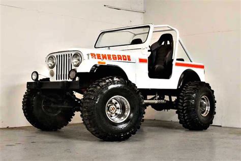 a white jeep parked in a garage next to a wall with an orange stripe on it
