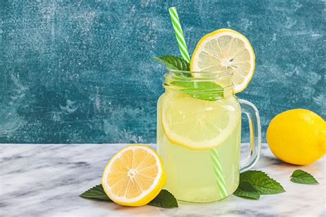 Lemon Lemonade In Mason Jar Glass Ofwith Lemons And Straw On Table