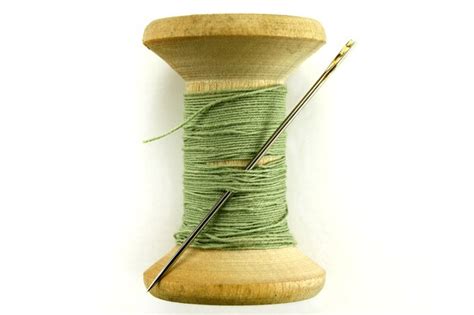 Premium Photo Vintage Wooden Spool With Sewing Threads And Needle On