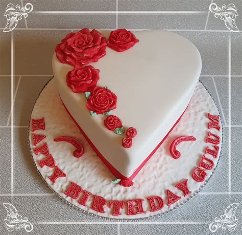 A Heart Shaped Birthday Cake With Roses On It