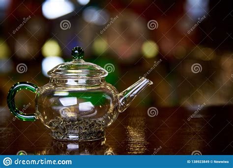 Glass Teapot With Tea Leaves On A Dark Background With Bokeh Stock