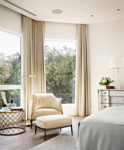 Bedroom with floor to ceiling windows and white curtains. Designer tips for spaces with low ceilings