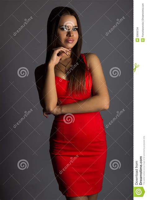 Moderner Brunette Im Sexy Roten Kleid Auf Grauem Hintergrund Stockfoto