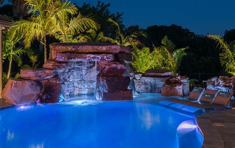 A Lagoon Pool And Floating Spa With Natural Stone Grotto Fire Pit And
