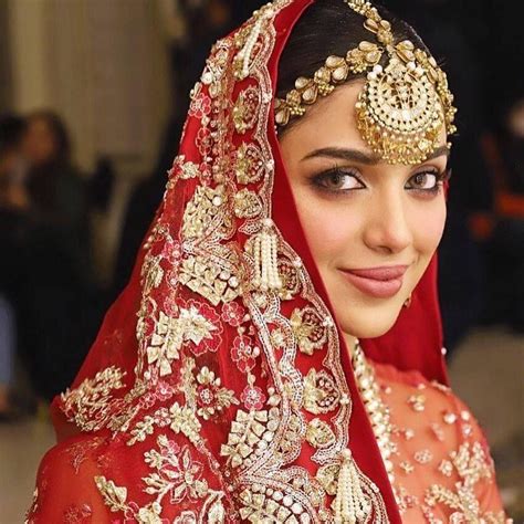 A Woman Wearing A Red And Gold Bridal Outfit
