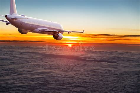 Commercial Airplane Jetliner Flying Above Dramatic Clouds Stock Photo