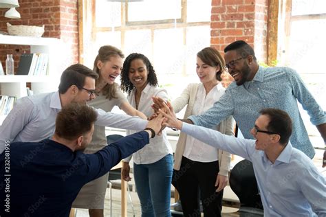 Excited Multiracial Colleagues Give High Five Involved In Teambuilding