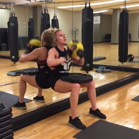Two Women In A Gym Doing Squats With Boxing Gloves