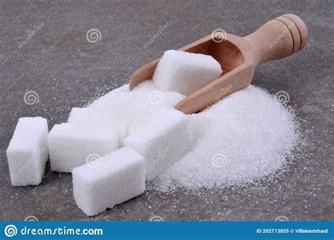 Wooden Spoon With Powdered Sugar And Pieces Of Sugar Close Up On Gray