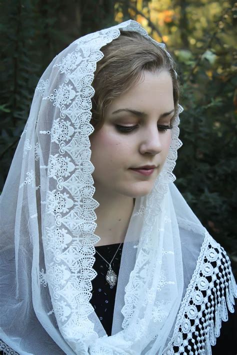 A Woman Wearing A White Veil With Lace On It