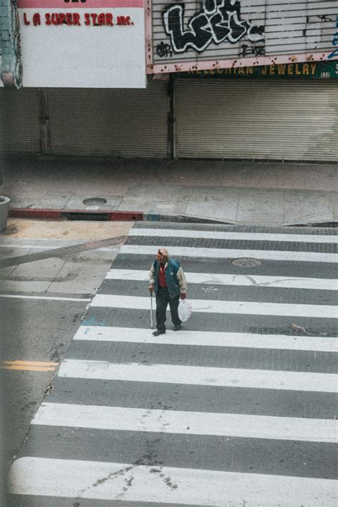 Person In Black Jacket Walking On Pedestrian Lane During Daytime Photo