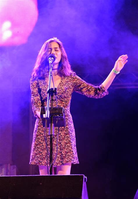 A Woman Standing In Front Of A Microphone On Stage