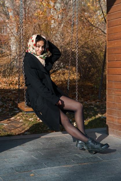 Una Hermosa Ni A Sentada En El Parque En Un Columpio En La Cabeza Es Un