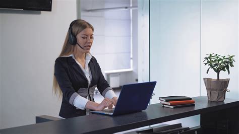 Young Professional Woman Receptionist Standing At Reception Desk