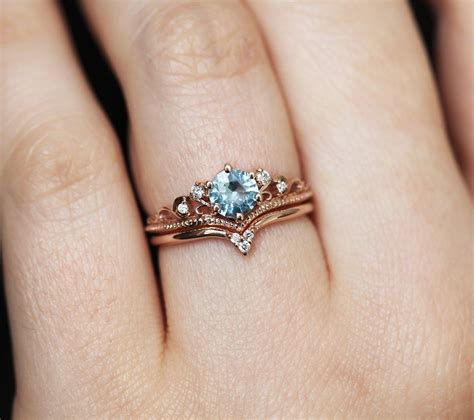 The center aquamarine is an emerald cut and is bezel set between a halo of diamonds. Bella Aquamarine Engagement Ring with Diamond Matching Band | Aquamarine engagement ring ...