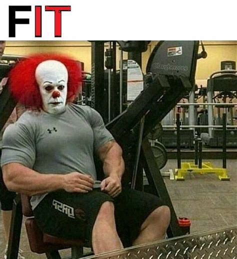 A Man With Red Hair Sitting In A Gym Machine Wearing A Clown Mask And