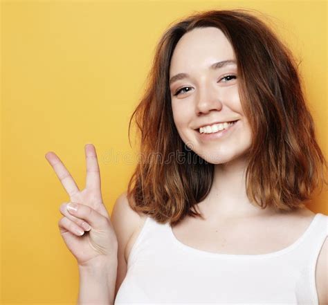 happy girl looking at camera with smile and showing peace sign with fingers stock image image