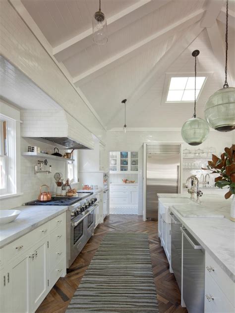 Large White Kitchen With Long Marble Countertop Island And Plank Board