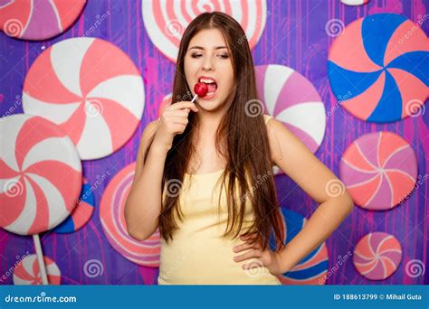 Portrait Of An Attractive Woman With A Lollipop In Her Hands On A