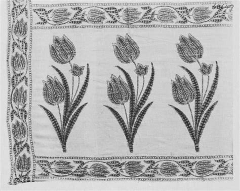 A Black And White Image Of Three Flowers On A Linen Tablecloth With An