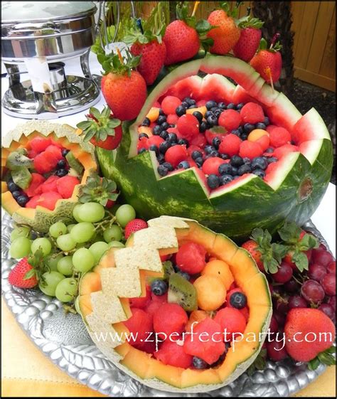 Various Fruits Are Arranged On A Platter With Silver Trays And Fruit In