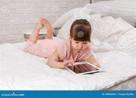 Little Child Girl Lies In Bed Uses Digital Tablet Stock Image Image