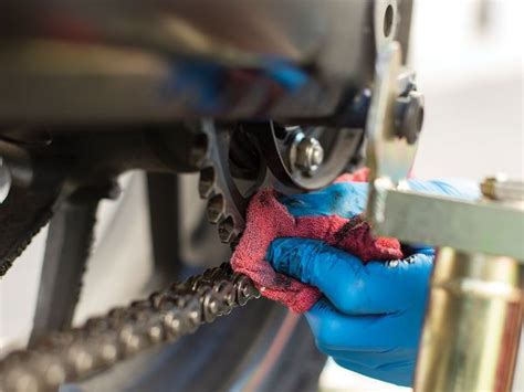 A Person In Blue Gloves Cleaning A Bike Tire