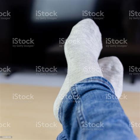 Relaxing Woman Laying In Sofa Front Of Tv Holding Her Legs On Table