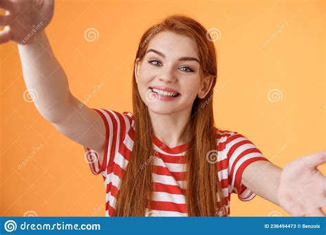 cheerful friendly redhead 20s woman extend arms hold camera both hands taking selfie tilt head