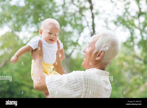 Asian Chinese Grandpa And Grandson Having Fun At Outdoor Garden Stock